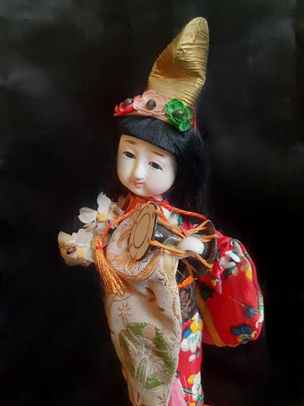 primer plano muñeca geisha tocando tambor 