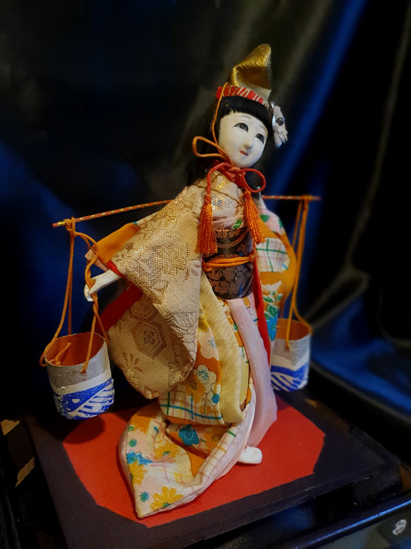 muñeca japonesa sobre base de madera con cubos y hermoso vestido