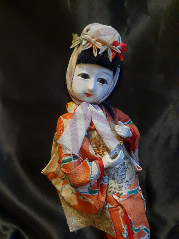 Geisha con rostro blanco de gofun y sombrero de flores